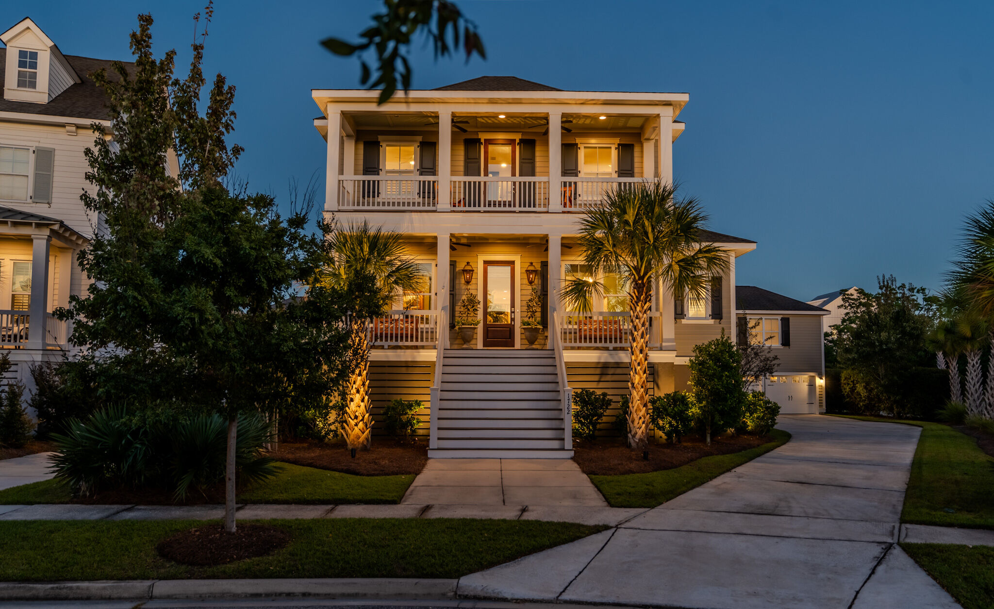 1722 Trewin Court at twilight, two stacked front piazzas facing Trewin Park on Daniel Island